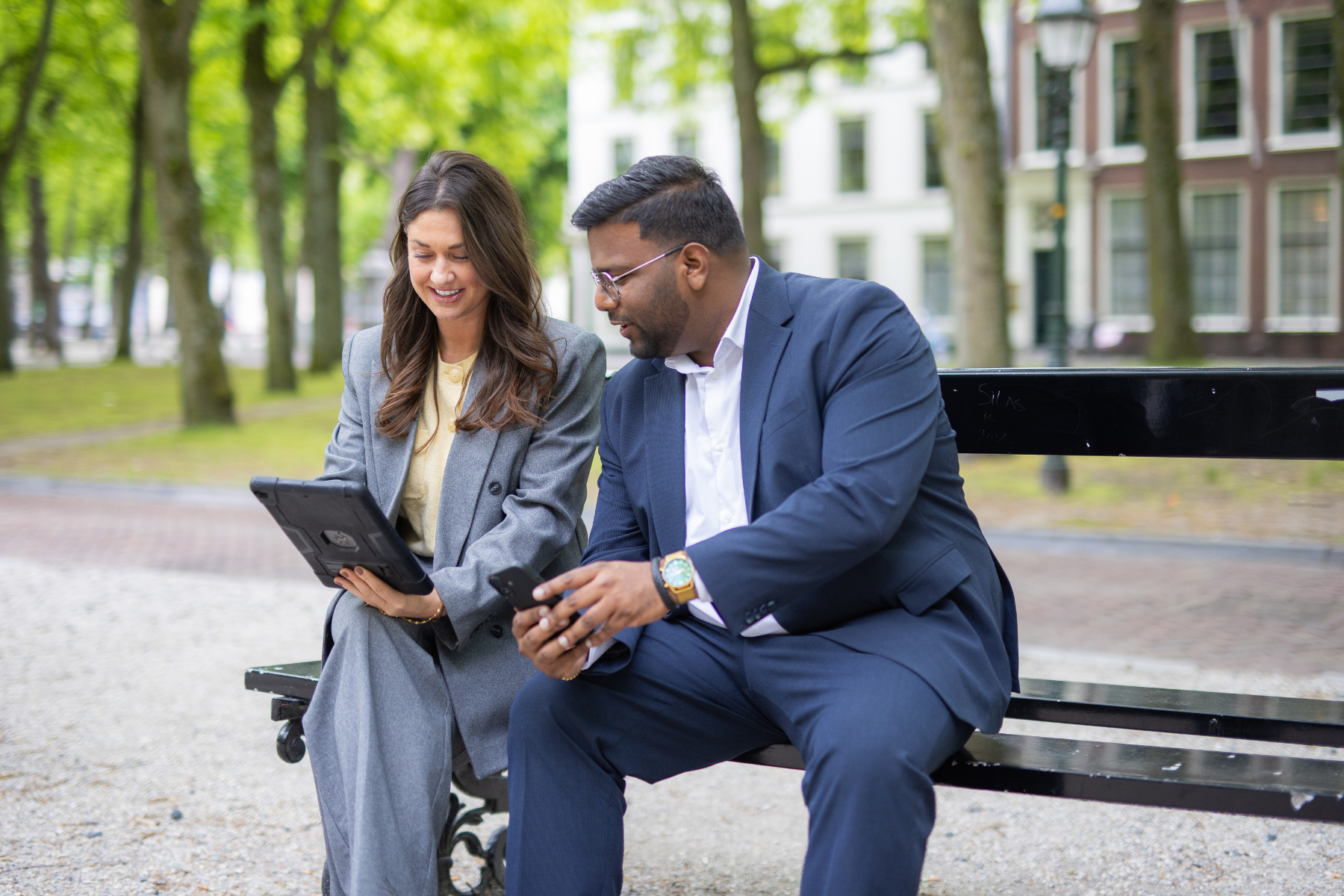 medewerkers van Level Real Estate bespreken op een bankje